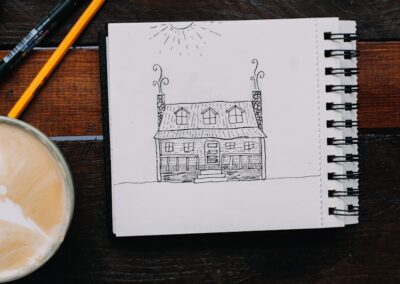 a drawing of a house next to a cup of coffee