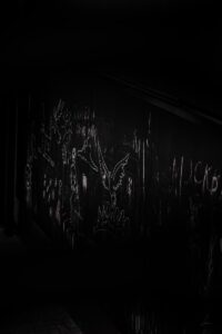 a dark room with graffiti written on the wall