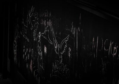 a dark room with graffiti written on the wall